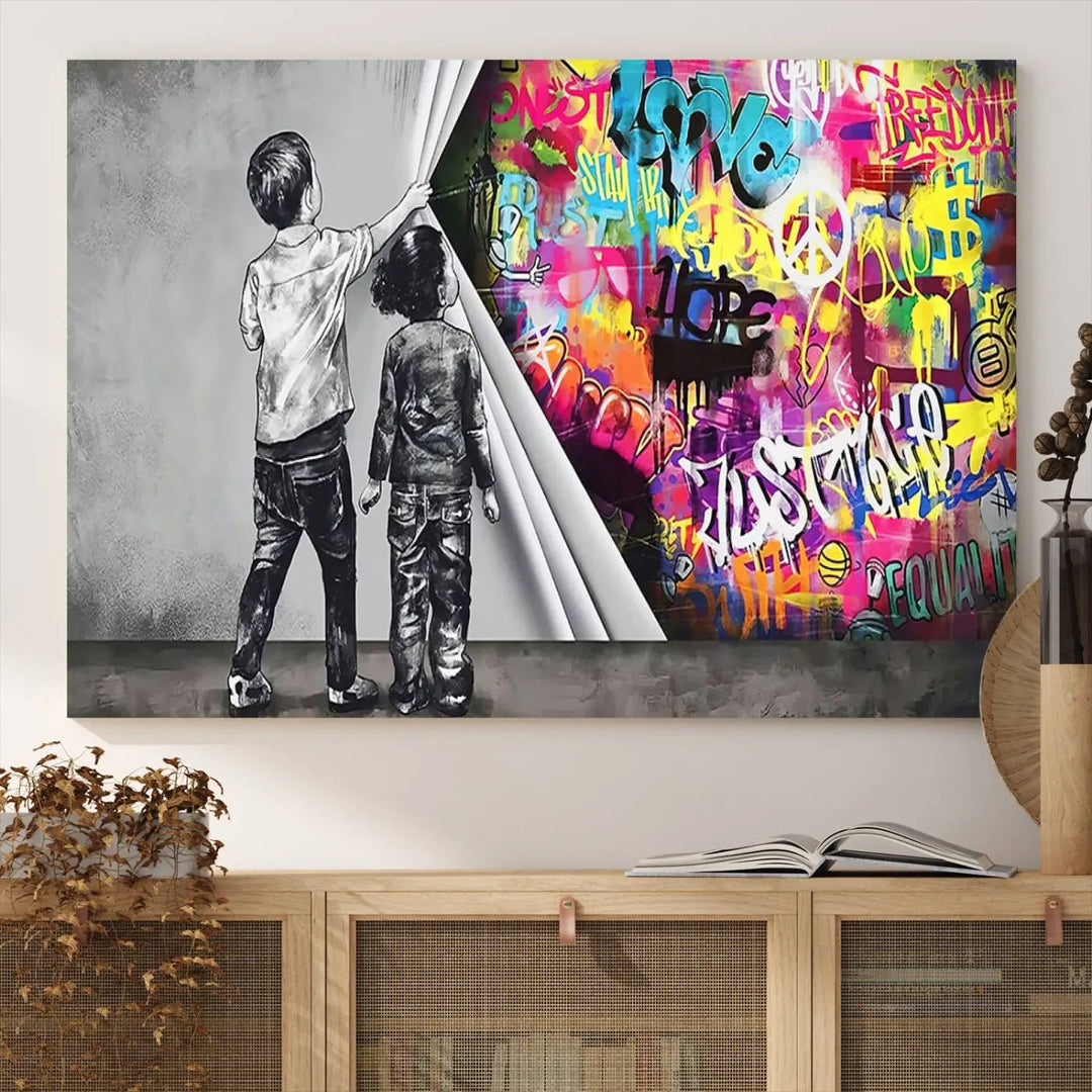 The Banksy Print - Street Art Canvas features a vibrant and bold image of two children lifting a curtain to reveal colorful graffiti. It's ready to hang, adding an urban modern decor vibe.