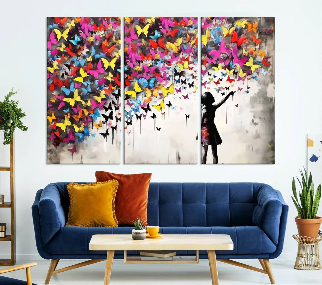 The Banksy Style Wall Art - Girl and Butterfly Explosion features a silhouette of a girl reaching for colorful butterflies on a three-panel canvas print.