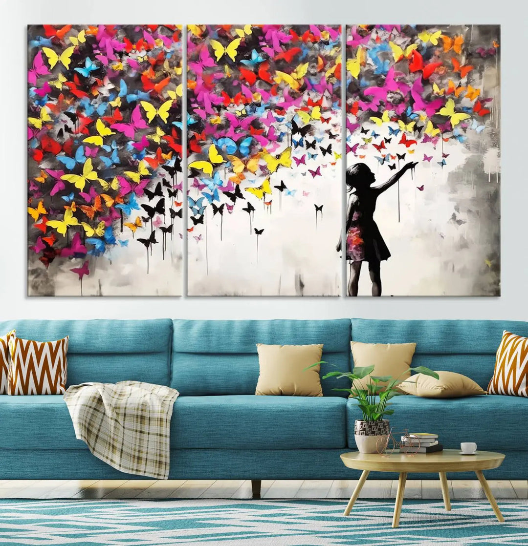 The Banksy Style Wall Art - Girl and Butterfly Explosion features a silhouette of a girl reaching for colorful butterflies on a three-panel canvas print.