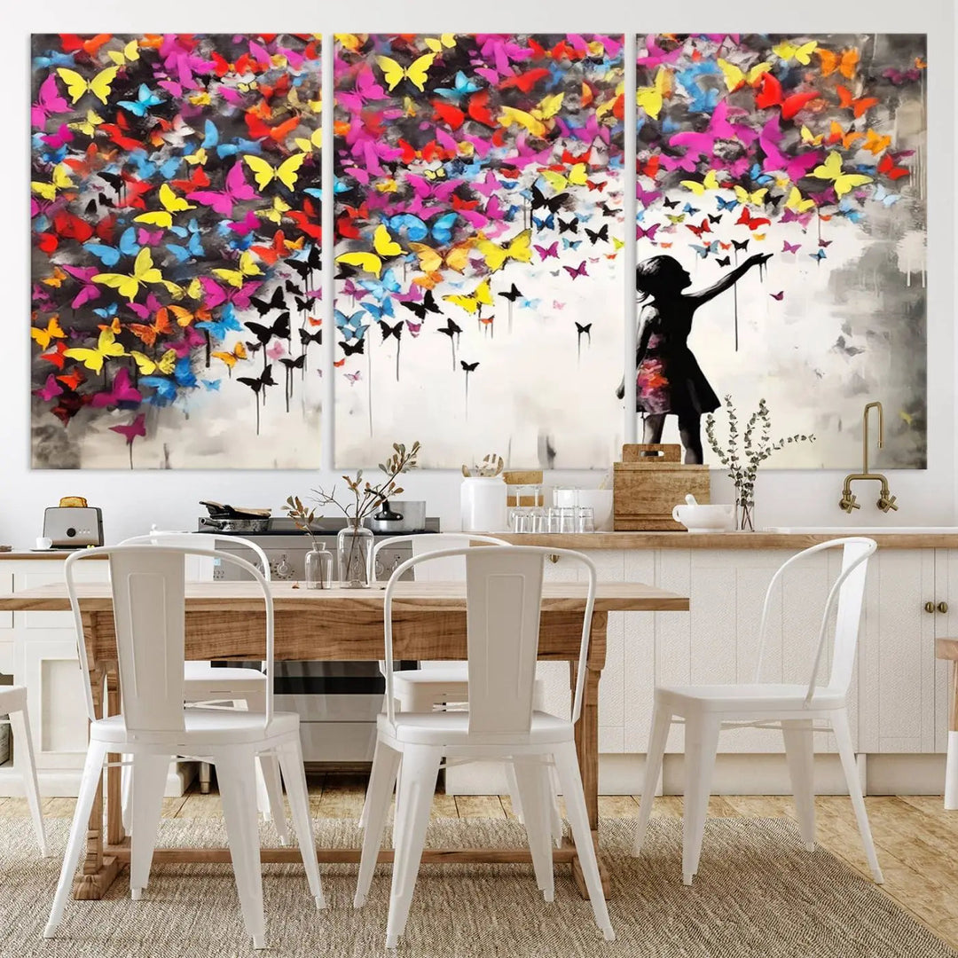 The Banksy Style Wall Art - Girl and Butterfly Explosion features a silhouette of a girl reaching for colorful butterflies on a three-panel canvas print.