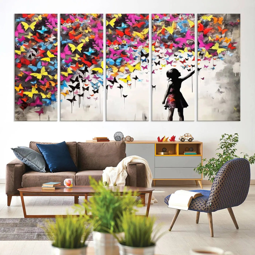 The Banksy Style Wall Art - Girl and Butterfly Explosion features a silhouette of a girl reaching for colorful butterflies on a three-panel canvas print.