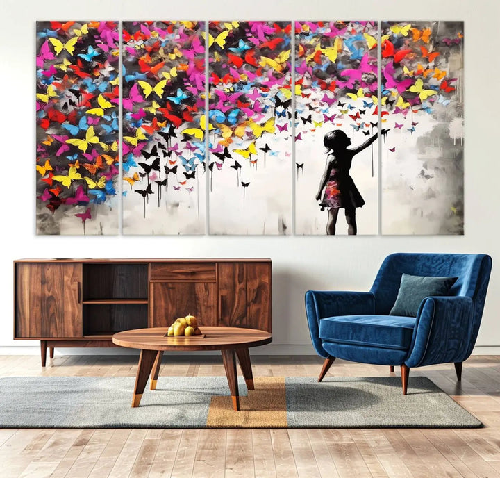 The Banksy Style Wall Art - Girl and Butterfly Explosion features a silhouette of a girl reaching for colorful butterflies on a three-panel canvas print.