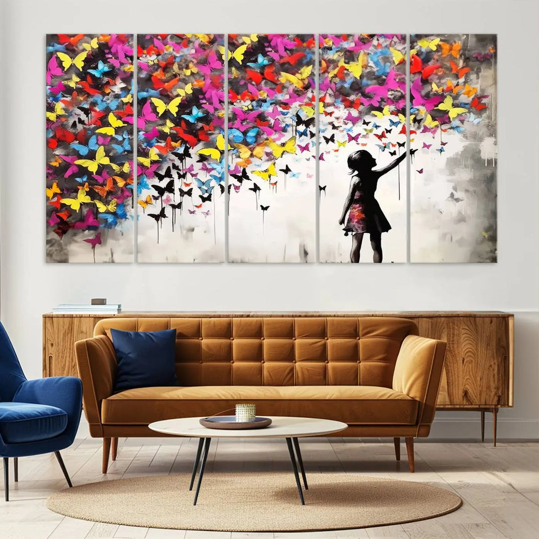 The Banksy Style Wall Art - Girl and Butterfly Explosion features a silhouette of a girl reaching for colorful butterflies on a three-panel canvas print.