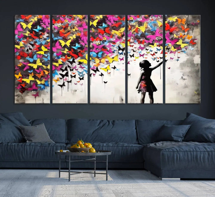 The Banksy Style Wall Art - Girl and Butterfly Explosion features a silhouette of a girl reaching for colorful butterflies on a three-panel canvas print.