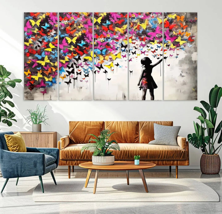 The Banksy Style Wall Art - Girl and Butterfly Explosion features a silhouette of a girl reaching for colorful butterflies on a three-panel canvas print.