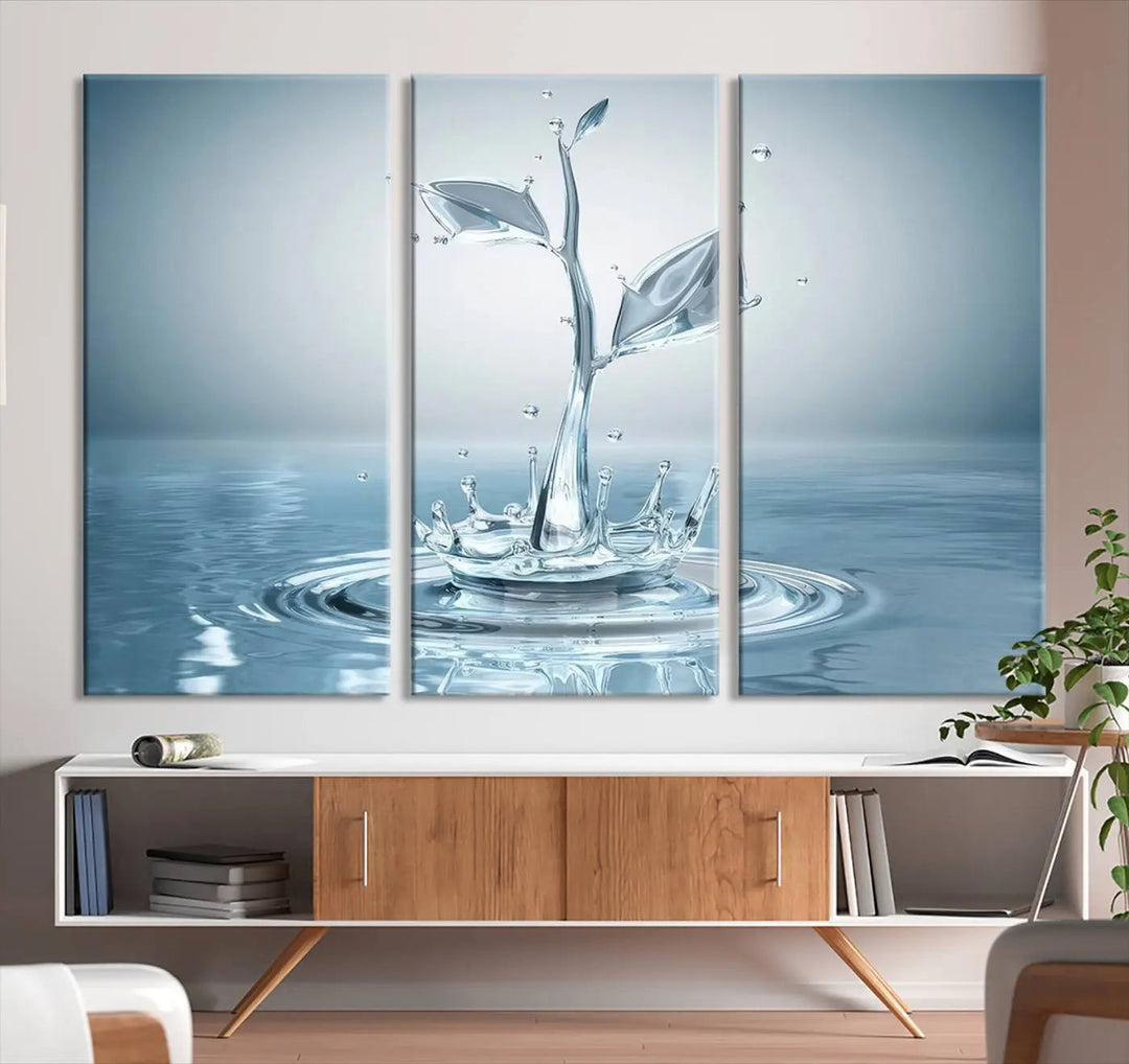 The living room features a three-panel wall art titled "Bathroom Wall Art Blue Leaf Canvas," showcasing water splash shapes that form plant-like designs on gallery-wrapped, museum-quality canvas.