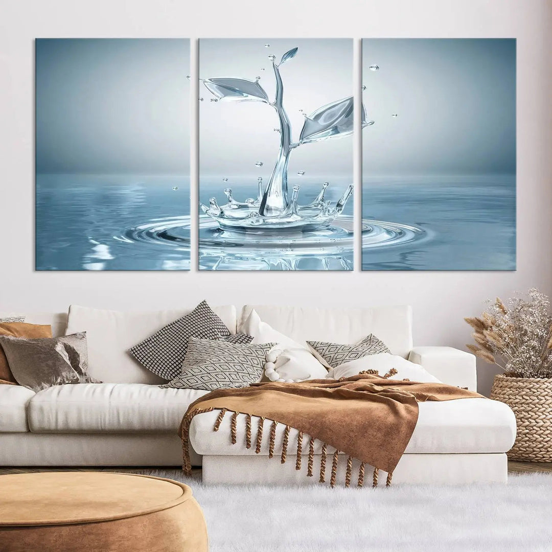 The living room features a three-panel wall art titled "Bathroom Wall Art Blue Leaf Canvas," showcasing water splash shapes that form plant-like designs on gallery-wrapped, museum-quality canvas.