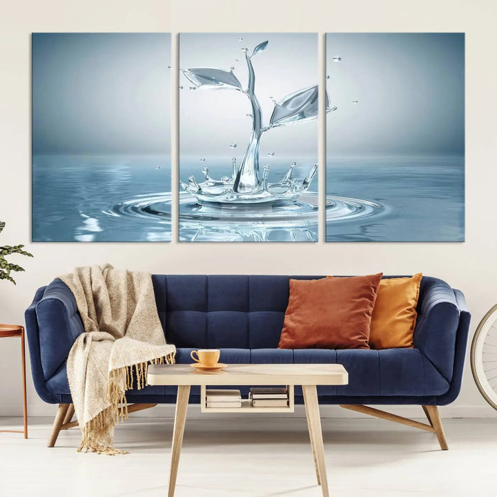 The living room features a three-panel wall art titled "Bathroom Wall Art Blue Leaf Canvas," showcasing water splash shapes that form plant-like designs on gallery-wrapped, museum-quality canvas.