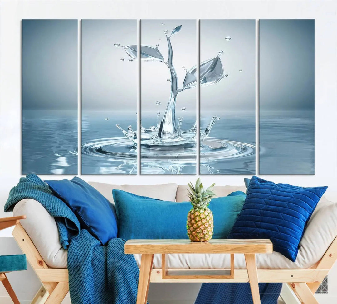 The living room features a three-panel wall art titled "Bathroom Wall Art Blue Leaf Canvas," showcasing water splash shapes that form plant-like designs on gallery-wrapped, museum-quality canvas.