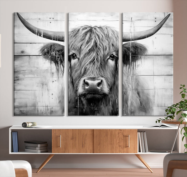 The Black White Highland Cow Wall Art Canvas Print, crafted on museum-quality canvases with a UV-protective coating, adds an elegant touch to the rustic wooden backdrop.