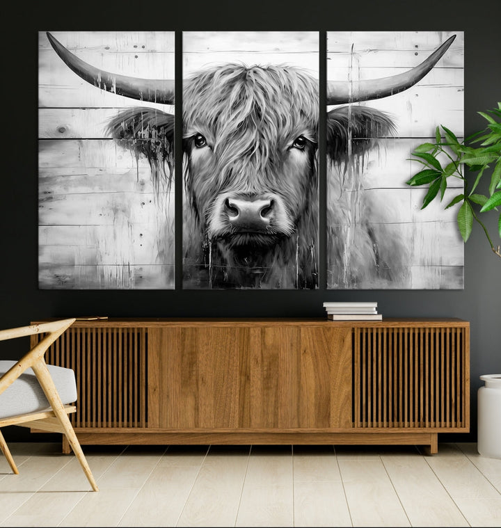 The Black White Highland Cow Wall Art Canvas Print, crafted on museum-quality canvases with a UV-protective coating, adds an elegant touch to the rustic wooden backdrop.