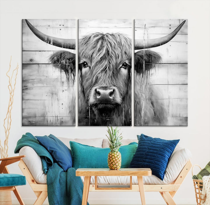 The Black White Highland Cow Wall Art Canvas Print, crafted on museum-quality canvases with a UV-protective coating, adds an elegant touch to the rustic wooden backdrop.