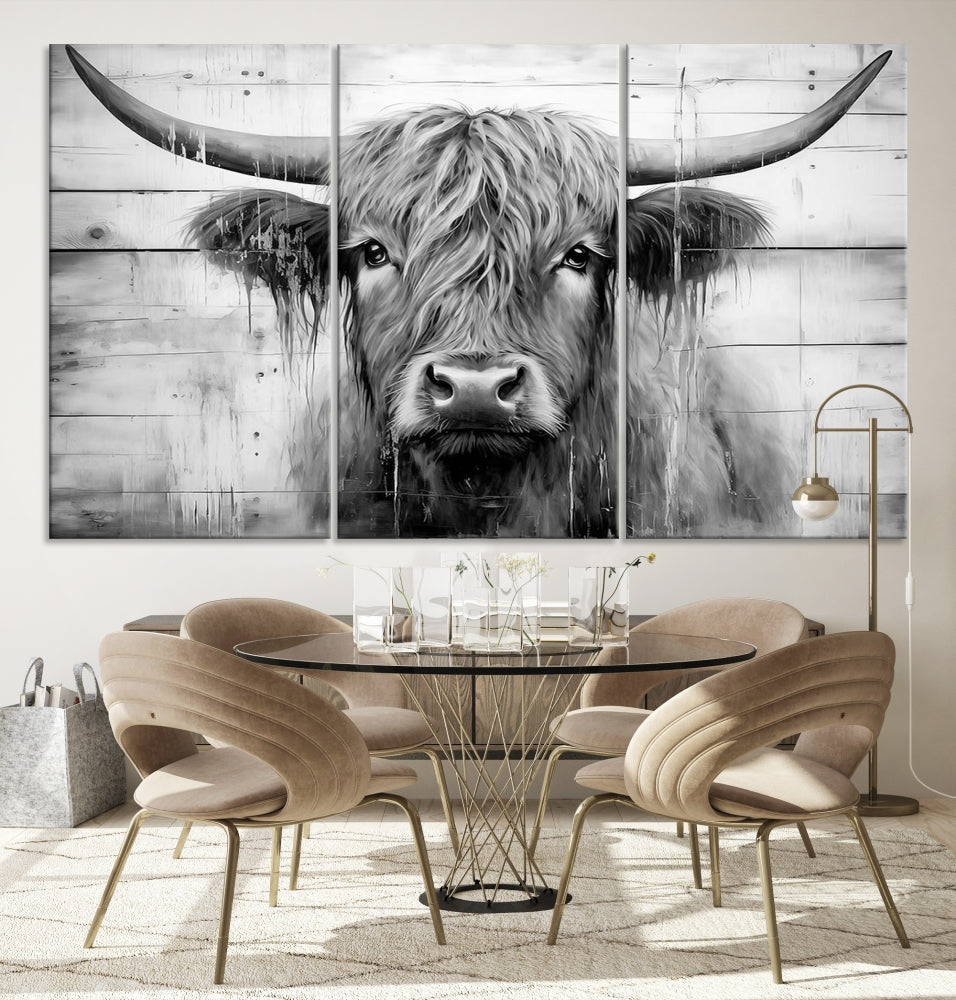 The Black White Highland Cow Wall Art Canvas Print, crafted on museum-quality canvases with a UV-protective coating, adds an elegant touch to the rustic wooden backdrop.