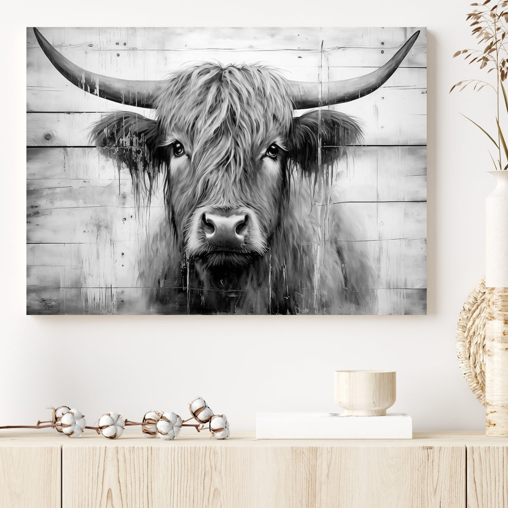 The Black White Highland Cow Wall Art Canvas Print, crafted on museum-quality canvases with a UV-protective coating, adds an elegant touch to the rustic wooden backdrop.