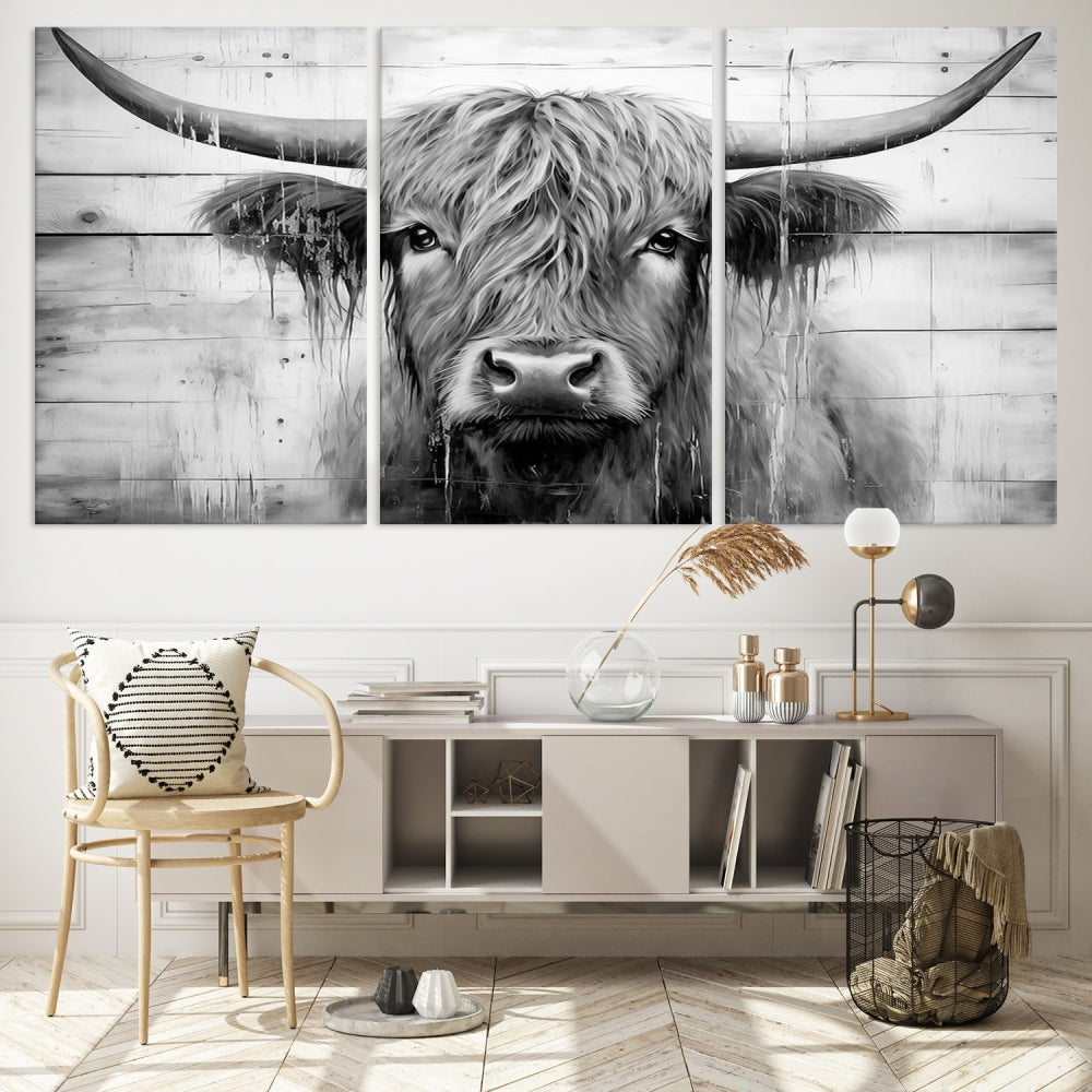 The Black White Highland Cow Wall Art Canvas Print, crafted on museum-quality canvases with a UV-protective coating, adds an elegant touch to the rustic wooden backdrop.