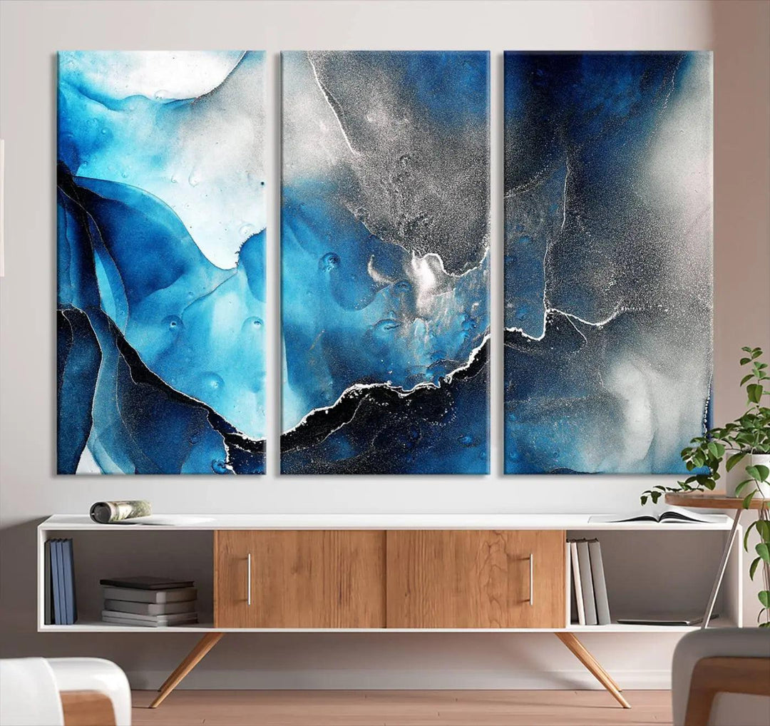 The Blue and Black Marble Fluid Effect Wall Art Abstract Canvas Prints feature three dynamic swirling patterns in blue, black, and white. Crafted on museum-quality canvases and enhanced with a UV-protective coating, these prints maintain their vibrant allure over time.