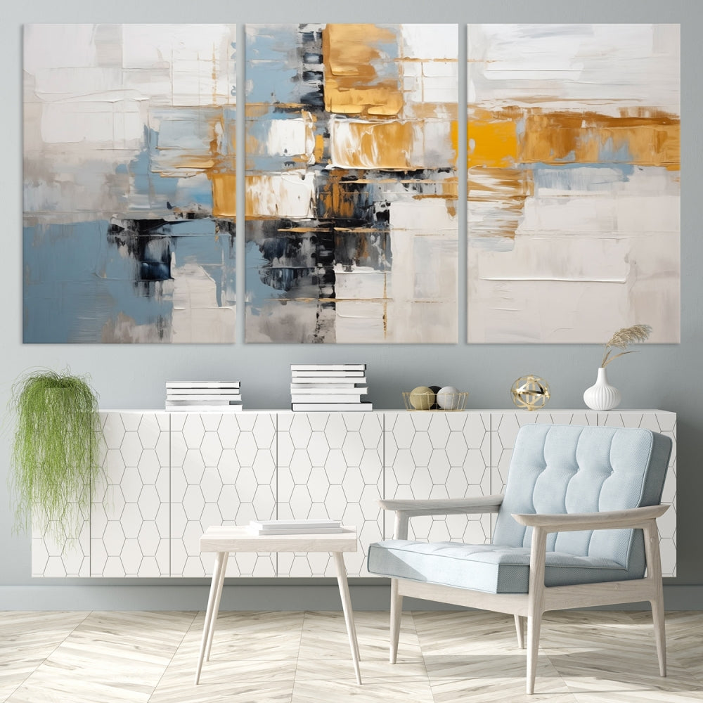 A stunning triptych of the Blue Orange Abstract Wall Art Canvas Print adorns the wall. These gallery-wrapped abstract pieces, showcasing blue, yellow, and white tones, feature a UV-protective coating to maintain their vivid colors.