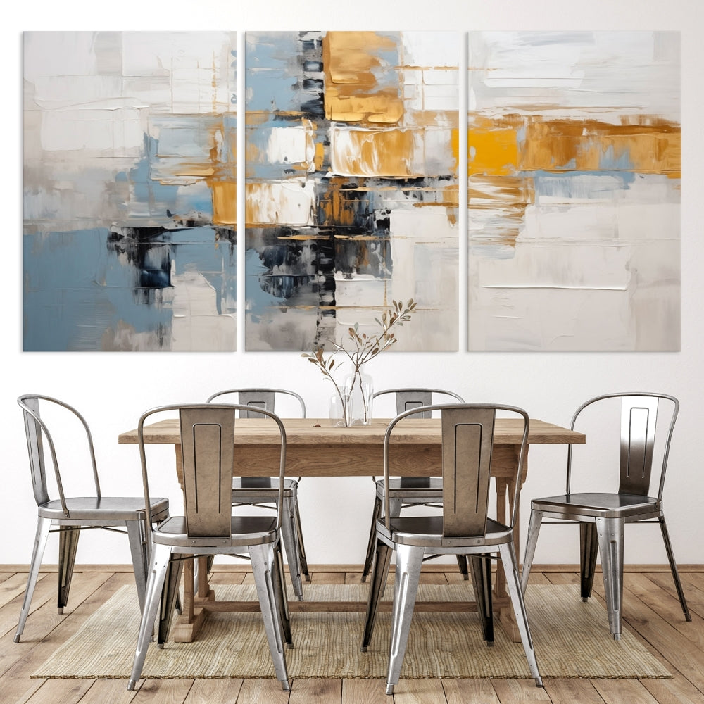 A stunning triptych of the Blue Orange Abstract Wall Art Canvas Print adorns the wall. These gallery-wrapped abstract pieces, showcasing blue, yellow, and white tones, feature a UV-protective coating to maintain their vivid colors.