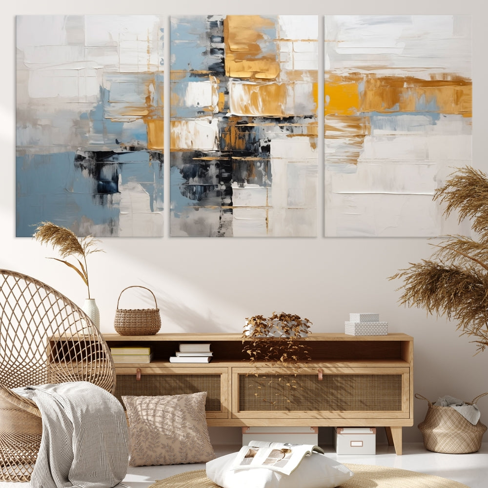 A stunning triptych of the Blue Orange Abstract Wall Art Canvas Print adorns the wall. These gallery-wrapped abstract pieces, showcasing blue, yellow, and white tones, feature a UV-protective coating to maintain their vivid colors.