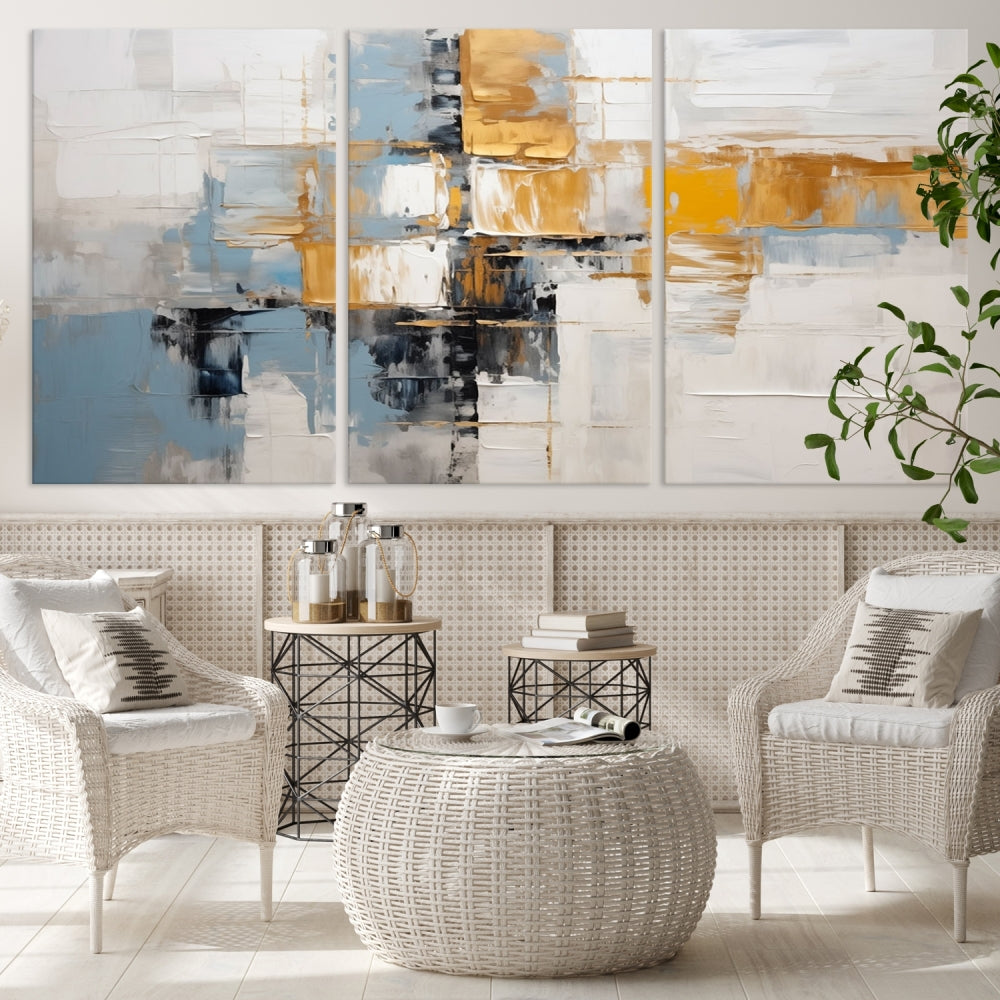 A stunning triptych of the Blue Orange Abstract Wall Art Canvas Print adorns the wall. These gallery-wrapped abstract pieces, showcasing blue, yellow, and white tones, feature a UV-protective coating to maintain their vivid colors.