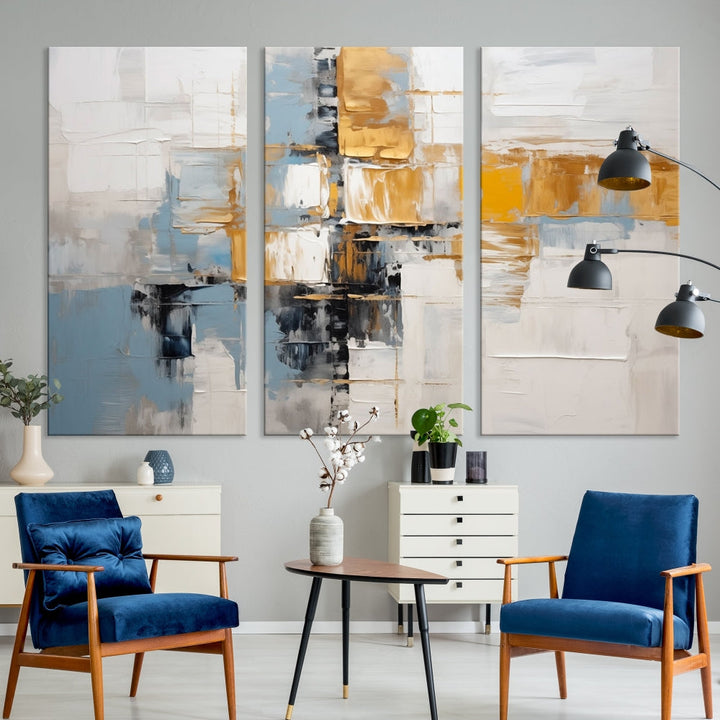 A stunning triptych of the Blue Orange Abstract Wall Art Canvas Print adorns the wall. These gallery-wrapped abstract pieces, showcasing blue, yellow, and white tones, feature a UV-protective coating to maintain their vivid colors.