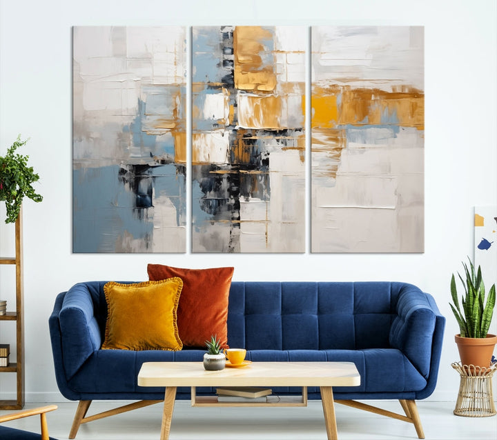 A stunning triptych of the Blue Orange Abstract Wall Art Canvas Print adorns the wall. These gallery-wrapped abstract pieces, showcasing blue, yellow, and white tones, feature a UV-protective coating to maintain their vivid colors.