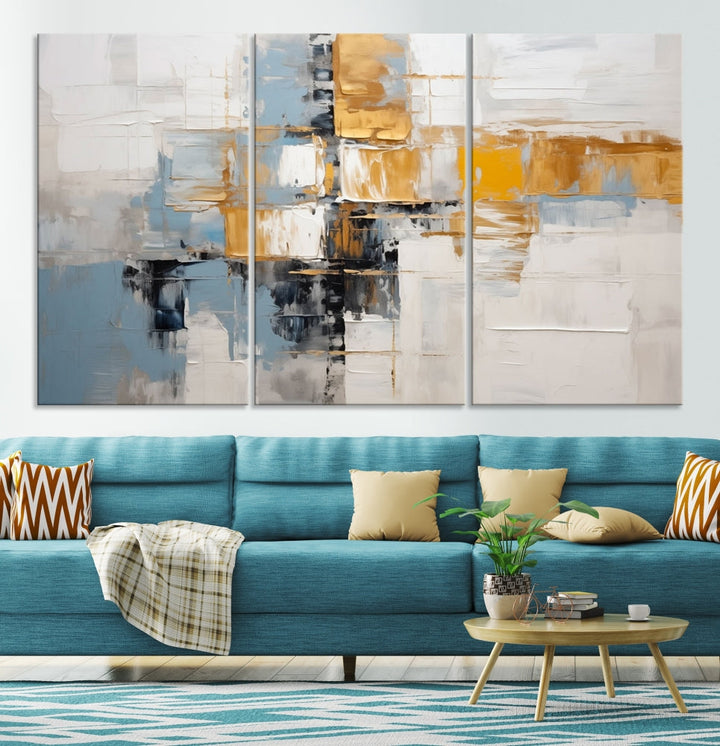 A stunning triptych of the Blue Orange Abstract Wall Art Canvas Print adorns the wall. These gallery-wrapped abstract pieces, showcasing blue, yellow, and white tones, feature a UV-protective coating to maintain their vivid colors.