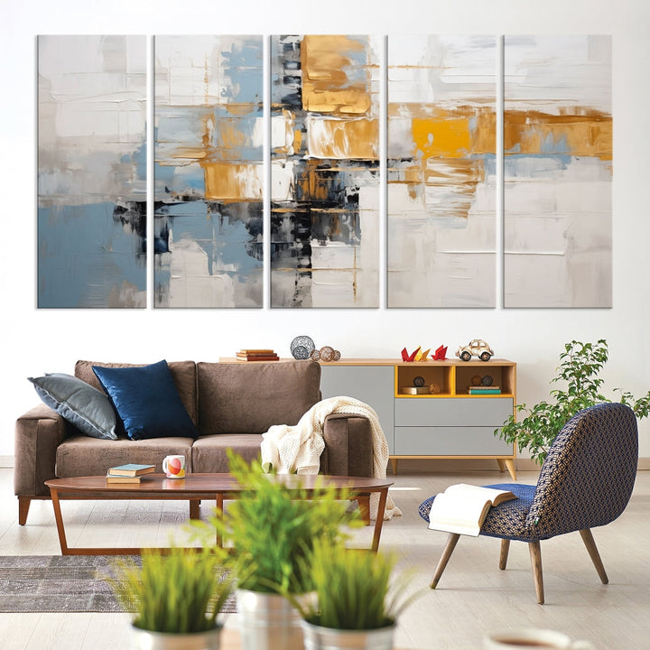 A stunning triptych of the Blue Orange Abstract Wall Art Canvas Print adorns the wall. These gallery-wrapped abstract pieces, showcasing blue, yellow, and white tones, feature a UV-protective coating to maintain their vivid colors.