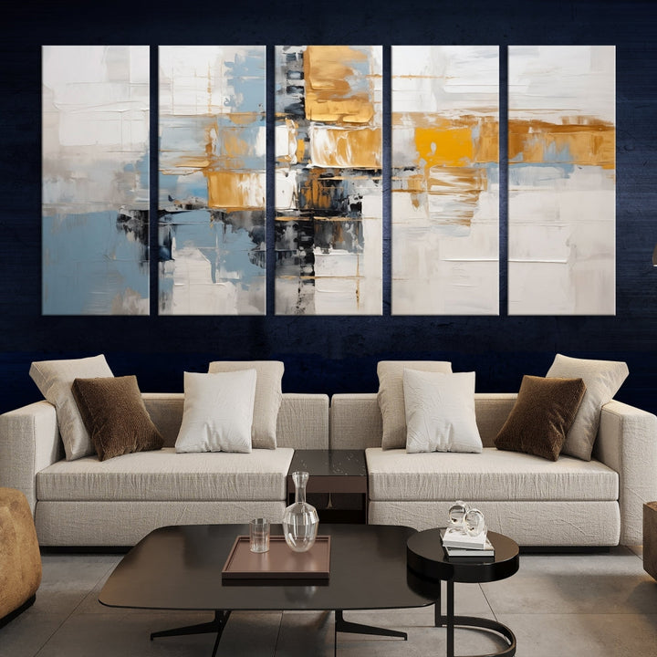 A stunning triptych of the Blue Orange Abstract Wall Art Canvas Print adorns the wall. These gallery-wrapped abstract pieces, showcasing blue, yellow, and white tones, feature a UV-protective coating to maintain their vivid colors.