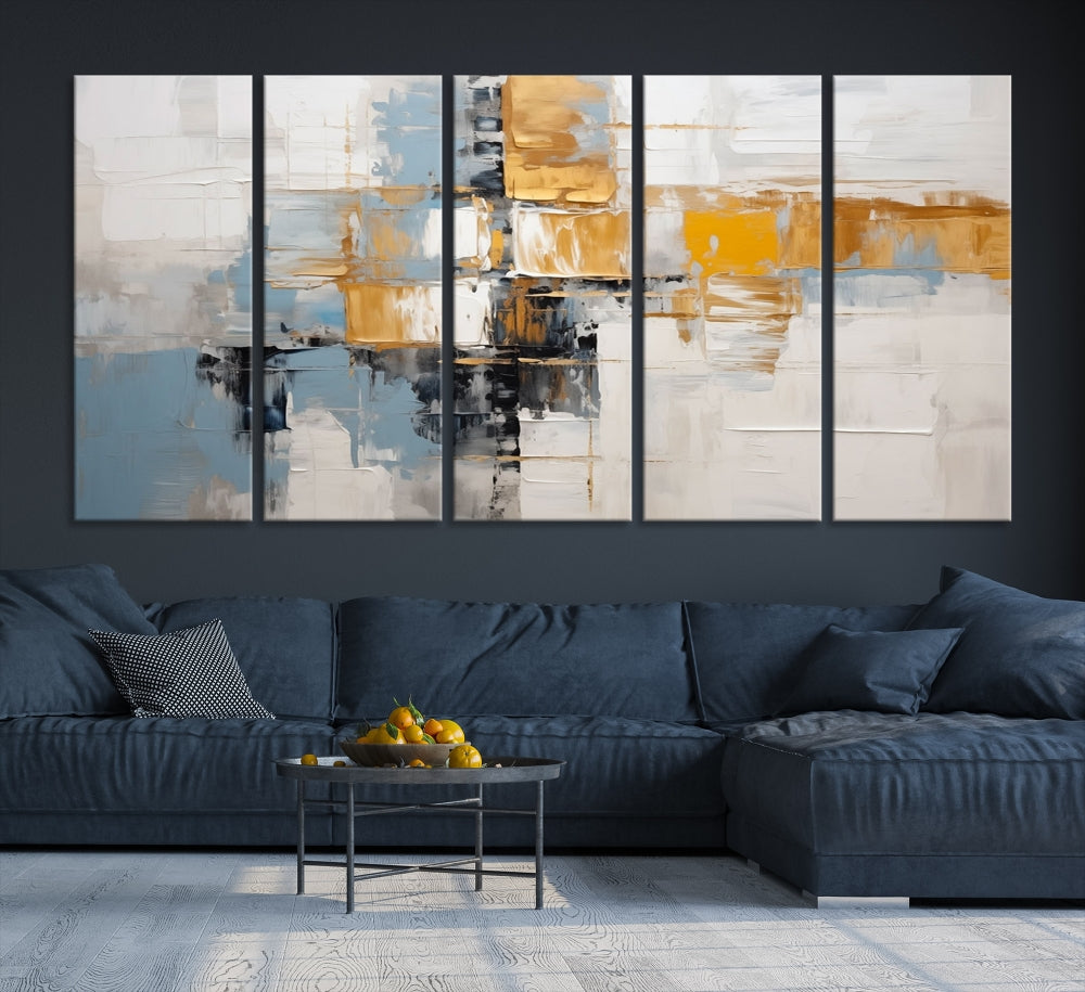 A stunning triptych of the Blue Orange Abstract Wall Art Canvas Print adorns the wall. These gallery-wrapped abstract pieces, showcasing blue, yellow, and white tones, feature a UV-protective coating to maintain their vivid colors.