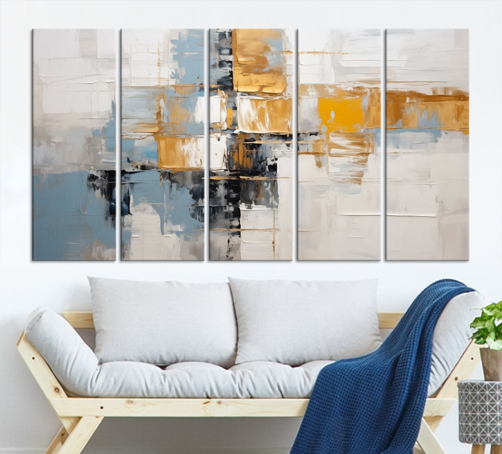 A stunning triptych of the Blue Orange Abstract Wall Art Canvas Print adorns the wall. These gallery-wrapped abstract pieces, showcasing blue, yellow, and white tones, feature a UV-protective coating to maintain their vivid colors.