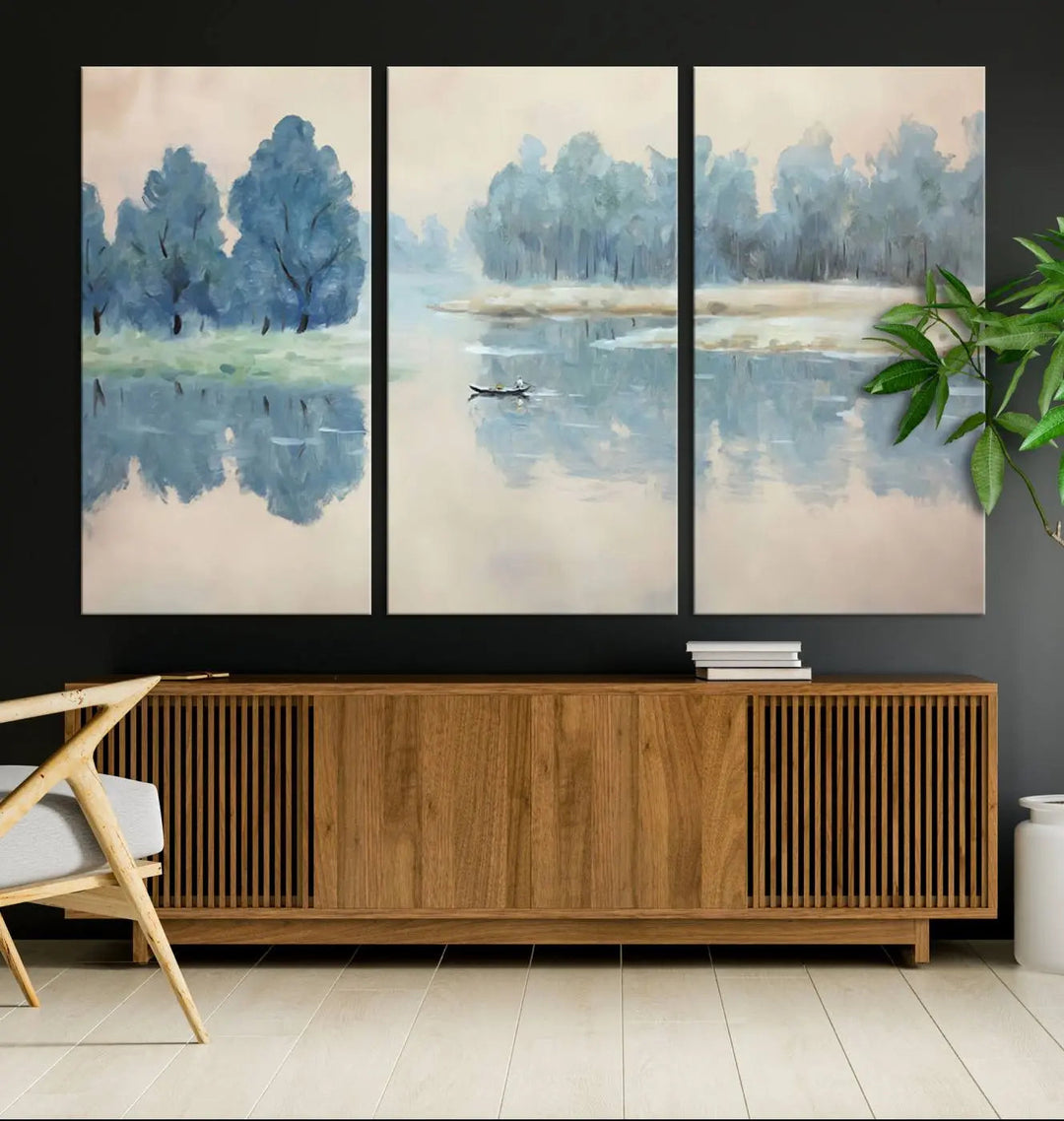 The triptych canvas print, "Blue Trees and Water Reflection Landscape," showcases a serene lake and boat scene through giclee printing. The blue trees reflecting on the water create a calming ambiance, making it an ideal choice for nature lovers.