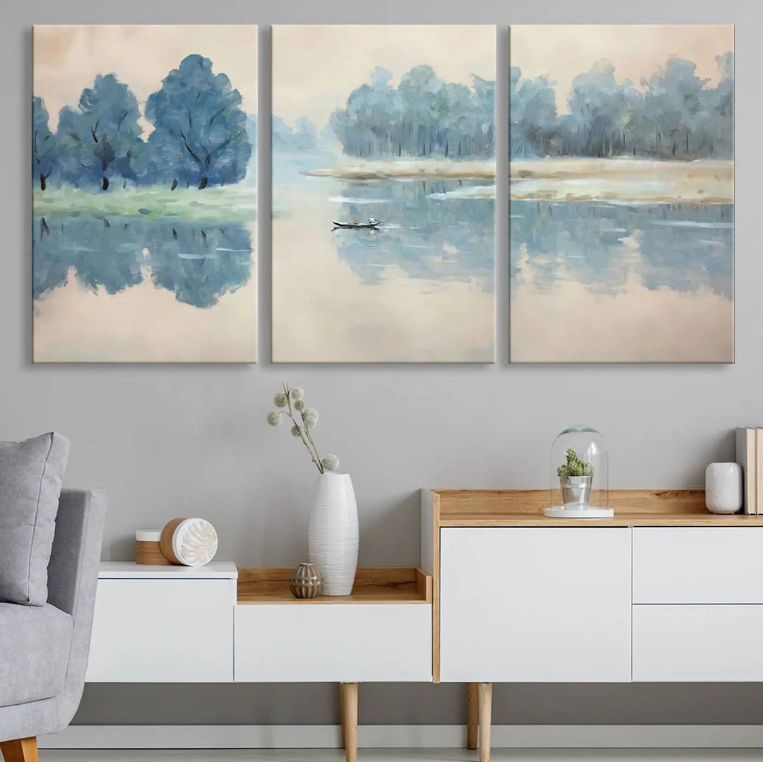 The triptych canvas print, "Blue Trees and Water Reflection Landscape," showcases a serene lake and boat scene through giclee printing. The blue trees reflecting on the water create a calming ambiance, making it an ideal choice for nature lovers.