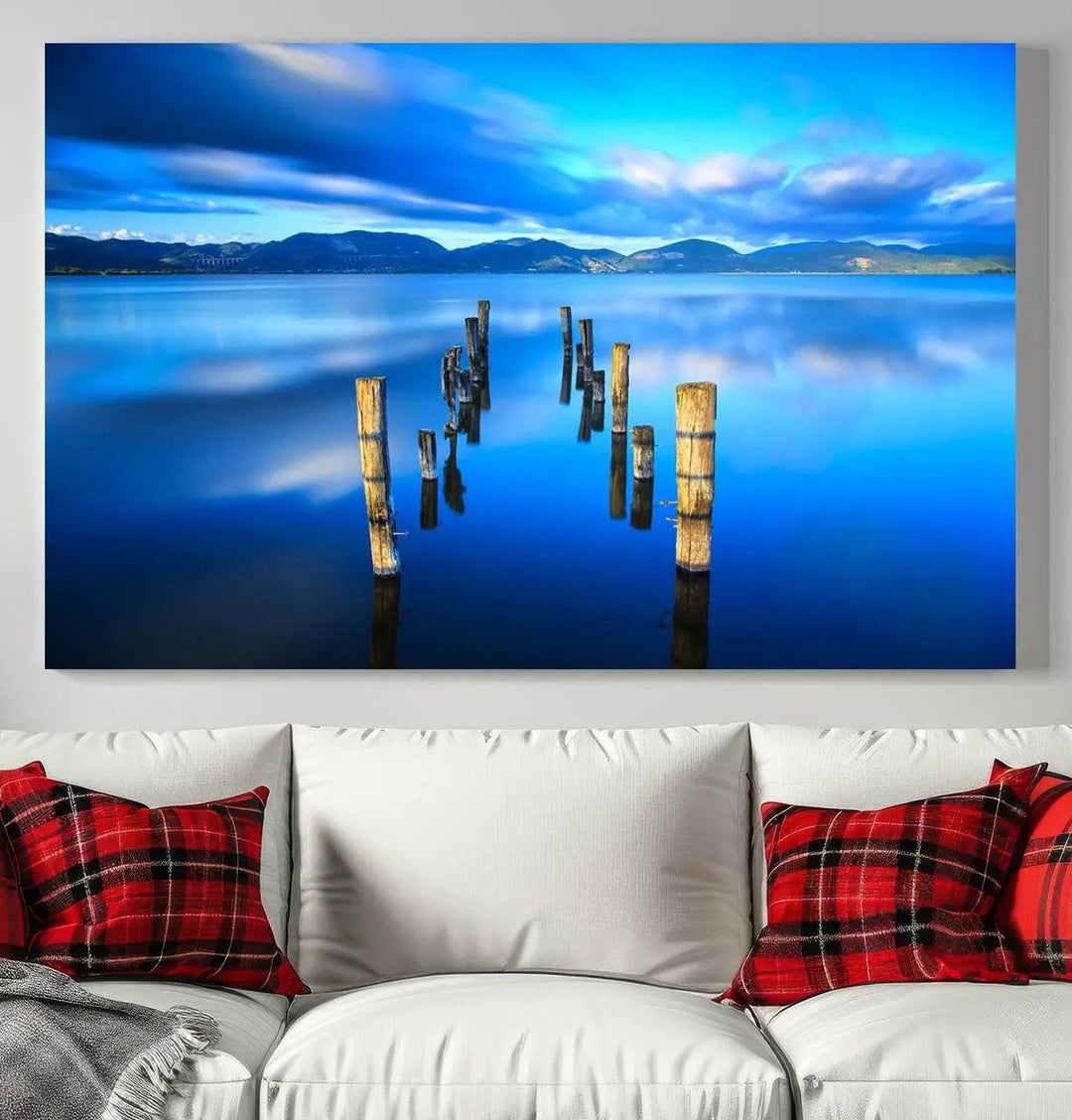 The Calm Waters Lake Canvas Art, featuring a tranquil pier reflection set against a mountainous backdrop, showcases its elegance with a gallery wrap and Canon print quality.