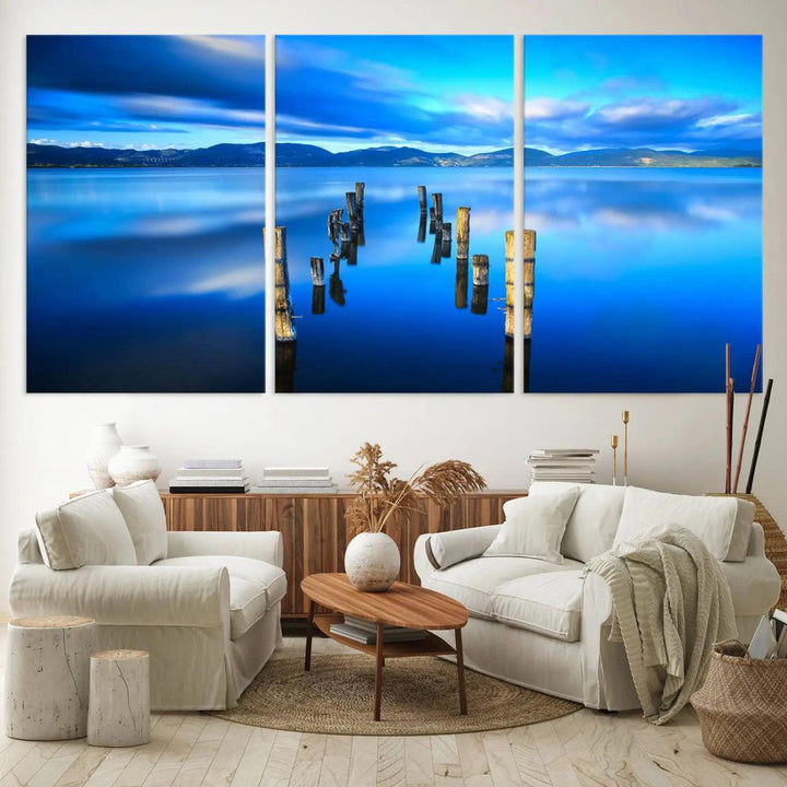 The Calm Waters Lake Canvas Art, featuring a tranquil pier reflection set against a mountainous backdrop, showcases its elegance with a gallery wrap and Canon print quality.