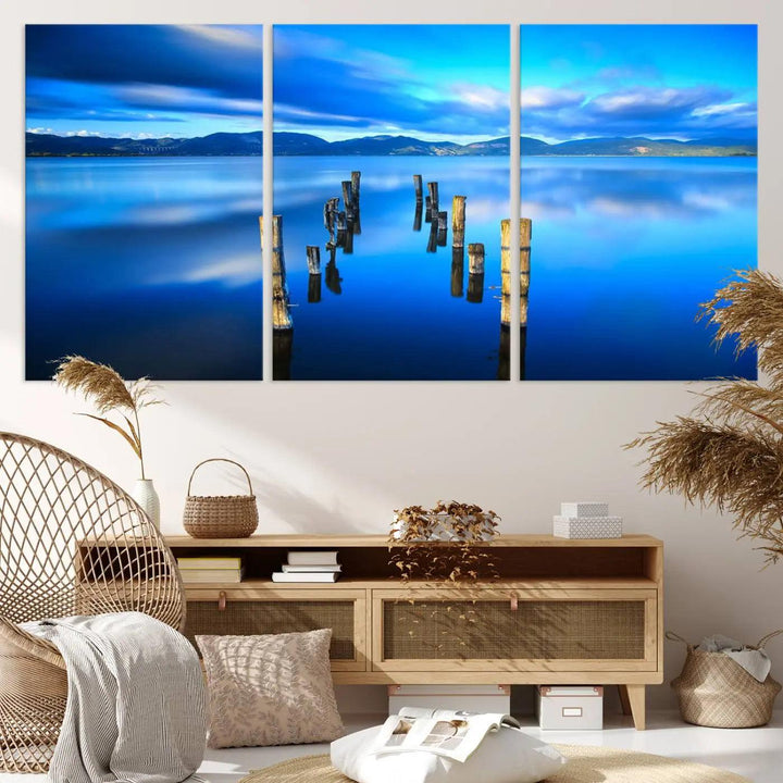 The Calm Waters Lake Canvas Art, featuring a tranquil pier reflection set against a mountainous backdrop, showcases its elegance with a gallery wrap and Canon print quality.