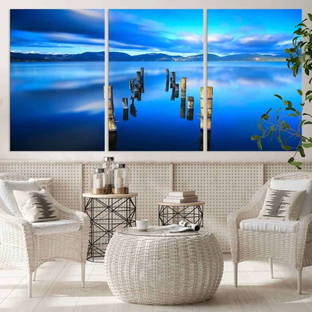 The Calm Waters Lake Canvas Art, featuring a tranquil pier reflection set against a mountainous backdrop, showcases its elegance with a gallery wrap and Canon print quality.