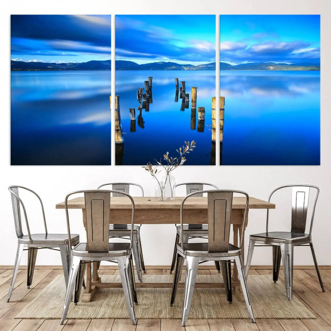 The Calm Waters Lake Canvas Art, featuring a tranquil pier reflection set against a mountainous backdrop, showcases its elegance with a gallery wrap and Canon print quality.