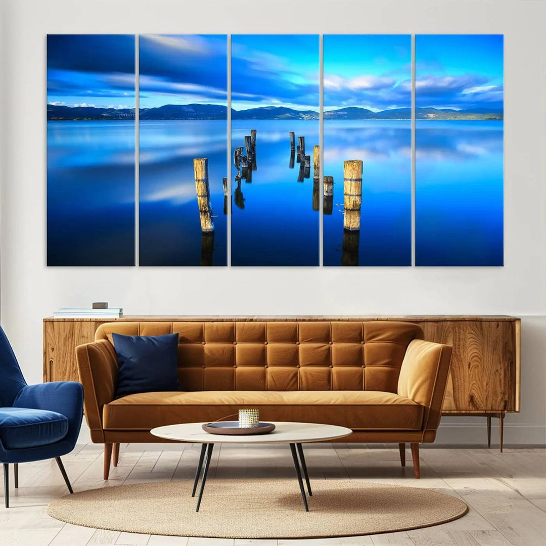 The Calm Waters Lake Canvas Art, featuring a tranquil pier reflection set against a mountainous backdrop, showcases its elegance with a gallery wrap and Canon print quality.