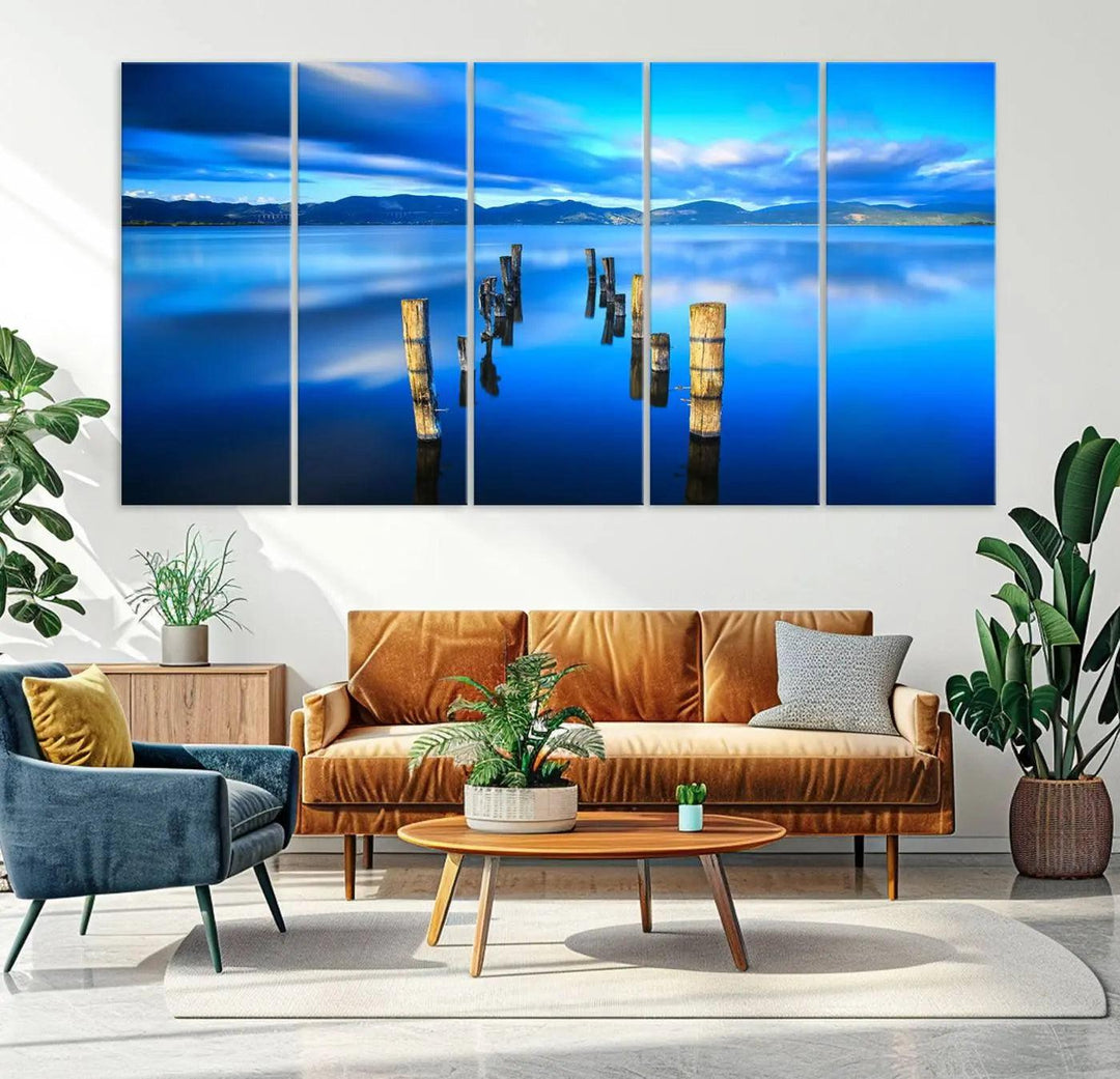 The Calm Waters Lake Canvas Art, featuring a tranquil pier reflection set against a mountainous backdrop, showcases its elegance with a gallery wrap and Canon print quality.