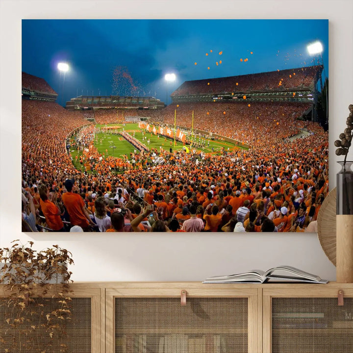 Imagine a stunning wall art canvas that captures the excitement and energy of a large football stadium packed with fans donned in orange. This Clemson University Tigers Football Team Print showcases Clemson Memorial Stadium under vibrant lights, transforming history into an enduring masterpiece.