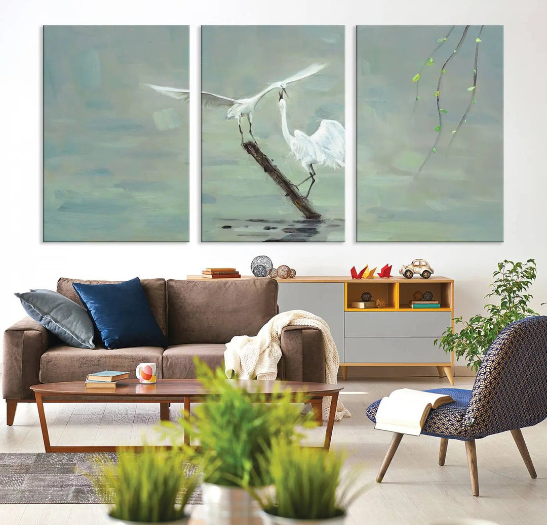 The living room showcases the "Elegant White Herons on Calm Waters" triptych canvas print.