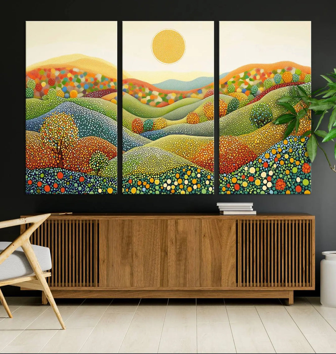 A framed Yayoi Kusama print featuring an abstract pointillism-inspired landscape of vibrant rolling hills and a sun.