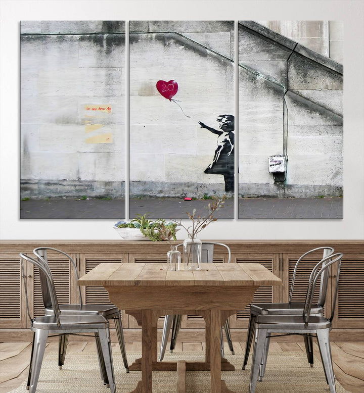 The "Girl with a Balloon Banksy Street Graffiti Art Canvas Print" is a gallery-quality wall art piece that features an image of a girl releasing a heart-shaped balloon. Handmade in the USA, this canvas artwork brings charm and emotion to any room.