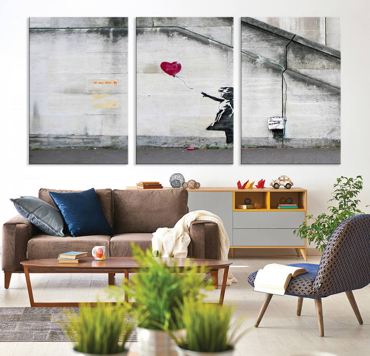 The "Girl with a Balloon Banksy Street Graffiti Art Canvas Print" is a gallery-quality wall art piece that features an image of a girl releasing a heart-shaped balloon. Handmade in the USA, this canvas artwork brings charm and emotion to any room.