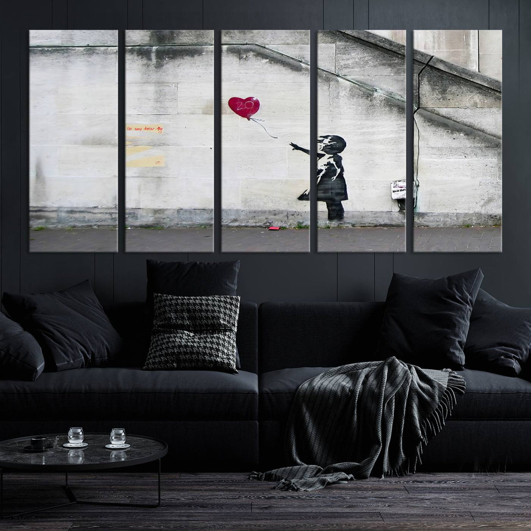 The "Girl with a Balloon Banksy Street Graffiti Art Canvas Print" is a gallery-quality wall art piece that features an image of a girl releasing a heart-shaped balloon. Handmade in the USA, this canvas artwork brings charm and emotion to any room.