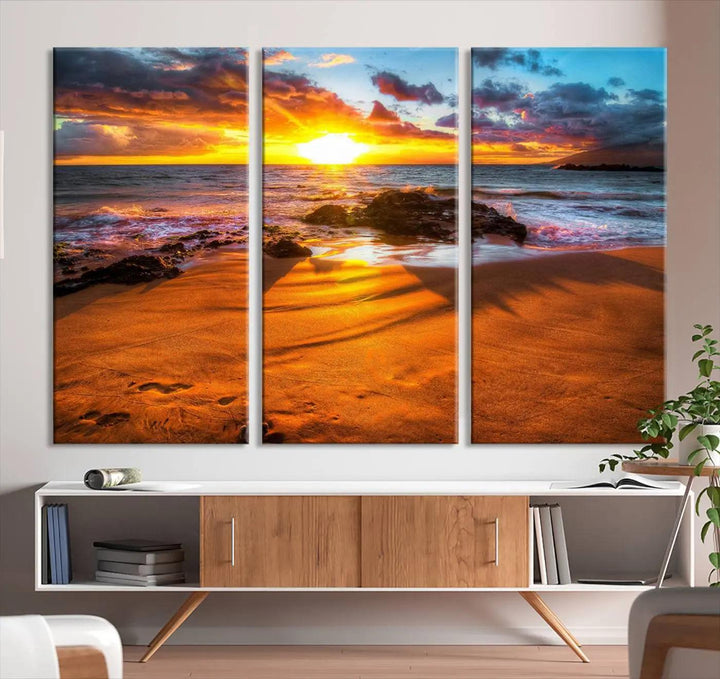 The vibrant panoramic view captured in the Golden Beach Sunset Canvas Art offers a serene scene of nature's tranquil beauty over the rocky shoreline. This Giclee canvas print, featuring a gallery wrap, beautifully depicts a breathtaking seascape for your space.