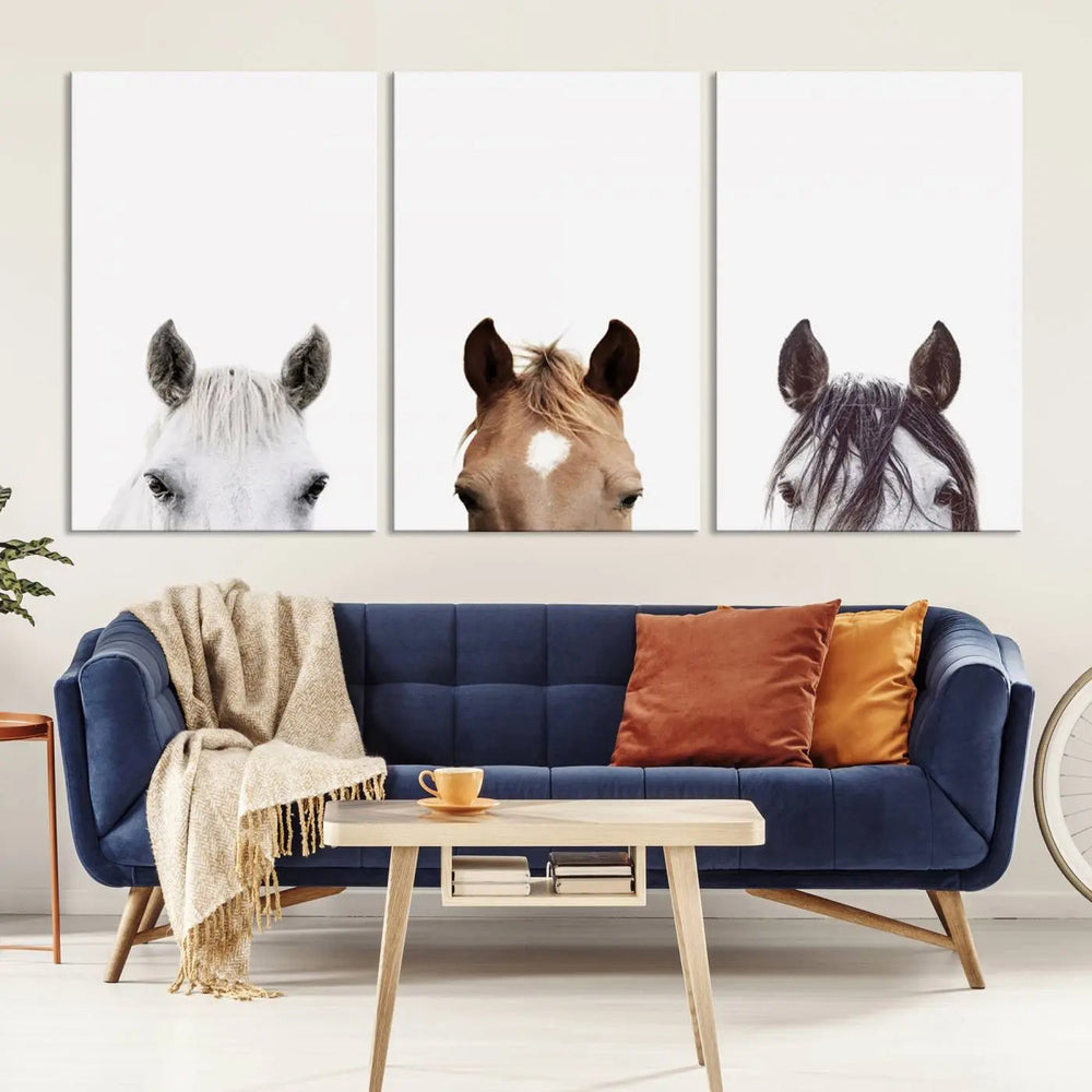 A stylish living room features the Horse Prints Set, a minimalist triptych of horse portraits crafted using giclée technology, hanging on the wall.