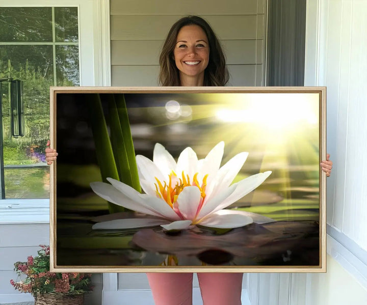 A serene Lotus Flower Wall Art Canvas Print depicts a water lily with sun rays, beautifully displayed on a light-colored wall.