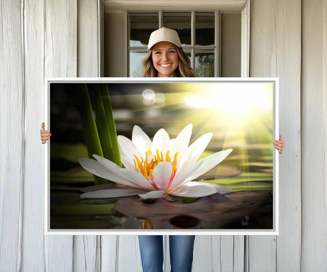 A serene Lotus Flower Wall Art Canvas Print depicts a water lily with sun rays, beautifully displayed on a light-colored wall.